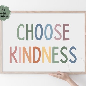 May include: A framed print with the text "CHOOSE KINDNESS" in rainbow colors. The letters are stylized and have a playful, hand-drawn look.