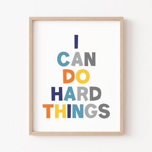 May include: A framed print with the text "I CAN DO HARD THINGS" in a colorful stacked design. The letters are in shades of blue, orange, yellow, and gray.