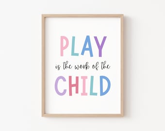 May include: A framed print with the text "PLAY is the work of the CHILD" in colorful letters. The letters are in shades of pink, blue, purple, and green.