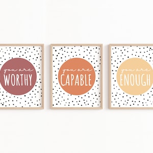 May include: Three framed prints with black polka dots on a white background. Each print features a large circle with a different color and the text "you are" followed by a word: "worthy", "capable", and "enough".