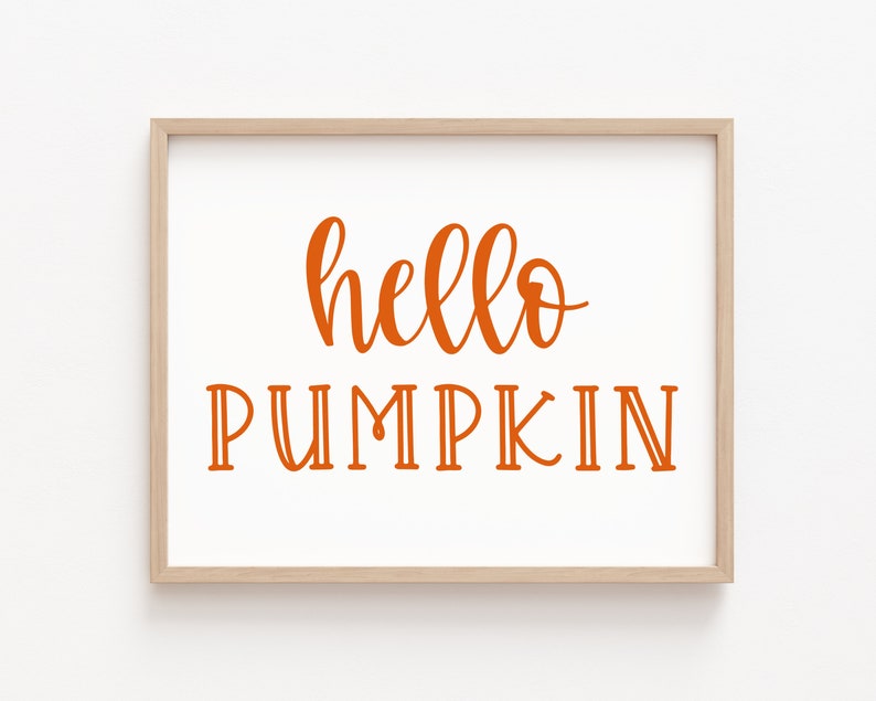 May include: A framed print with the text "hello pumpkin" in orange lettering on a white background.