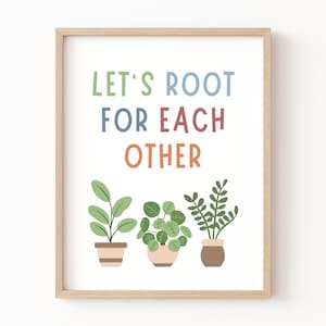May include: A framed print with the text "Let's Root For Each Other" in colorful letters. Three potted plants are shown below the text.