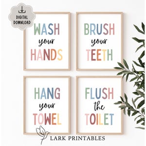 Puede incluir: Cuatro impresiones enmarcadas con texto pastel: "Lávate las manos", "Cepíllate los dientes", "Cuelga tu toalla" y "Tira de la cadena". Cada impresión tiene un fondo blanco, un marco de madera y un icono de descarga digital.