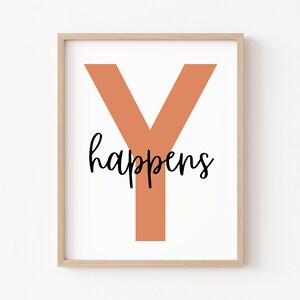 May include: A framed print with a large orange "Y" and the text "happens" in black cursive lettering.