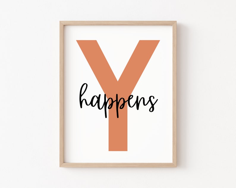 May include: A framed print with a large orange "Y" and the text "happens" in black cursive lettering.