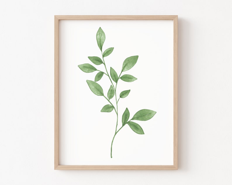May include: A framed print of a watercolor painting of a green leafy branch with a white background.
