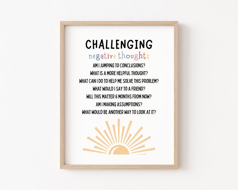 May include: A printable poster with a light brown wooden frame. The poster has a white background with black text that reads "CHALLENGING negative thoughts" and a list of questions to challenge negative thoughts. The poster also features a yellow sun graphic.