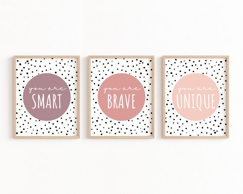 May include: Three framed prints with a white background and black polka dots. Each print features a large pink or purple circle with white text that reads "You are SMART", "You are BRAVE", and "You are UNIQUE".