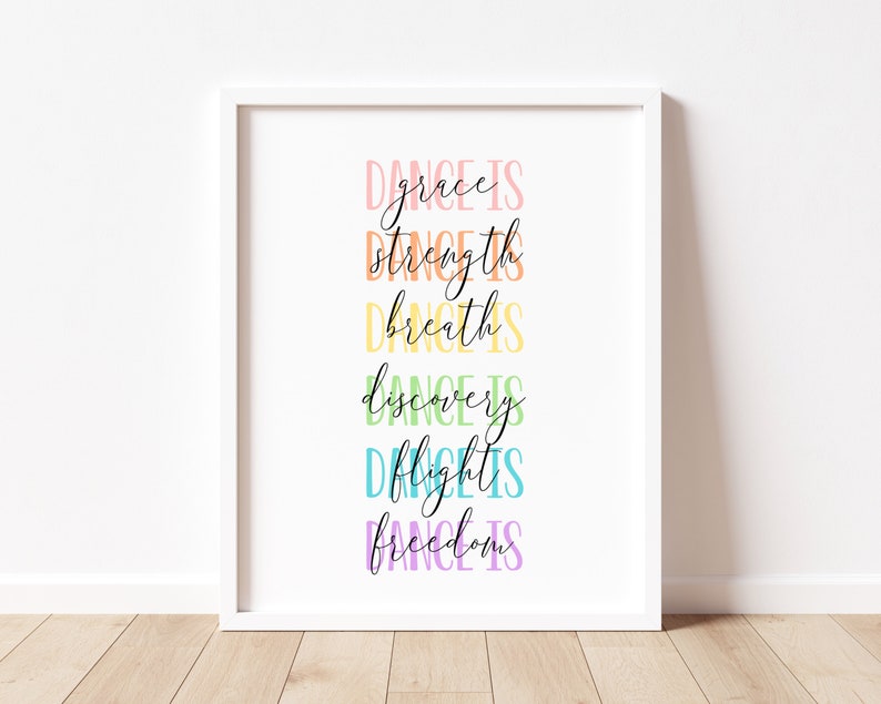 May include: A white framed print with the text "Dance is grace, Dance is strength, Dance is breath, Dance is discovery, Dance is flight, Dance is freedom" in rainbow colors.