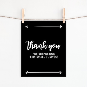 以下が含まれることがあります： 「この小さなビジネスを支援してくれてありがとう」というテキストが書かれた白黒の看板です。