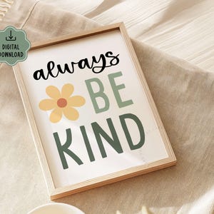 May include: A framed print with the words "always BE KIND" in black and green lettering, with a yellow flower graphic. The print is in a light wood frame and has a "DIGITAL DOWNLOAD" icon in the upper left corner.