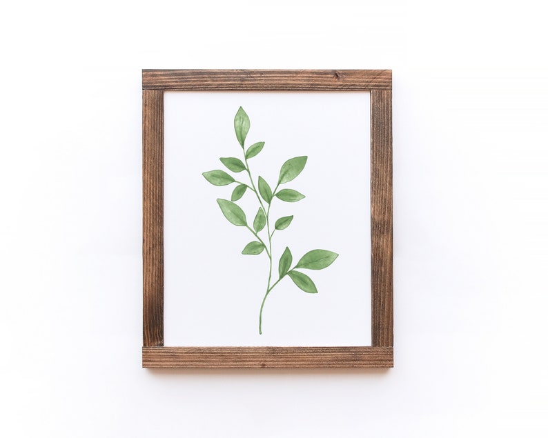 May include: A framed watercolor painting of a green leafy branch with a white background.