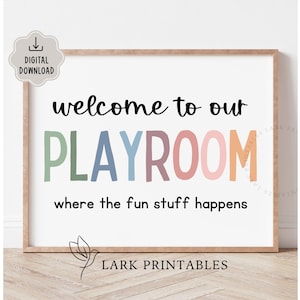 May include: A framed print with the words "welcome to our PLAYROOM where the fun stuff happens." The word PLAYROOM is in colorful letters. The print has a light brown frame and a white background. The words "DIGITAL DOWNLOAD" are in a small box in the upper left corner.