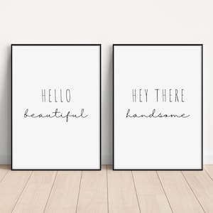 Puede incluir: Dos impresiones enmarcadas en negro con fondos blancos. La impresión de la izquierda dice "Hello beautiful" y la impresión de la derecha dice "Hey there handsome".