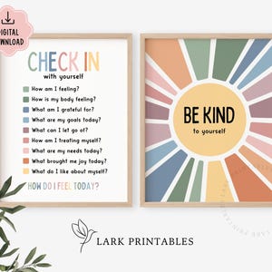 May include: Two framed prints with inspirational messages. One print says "CHECK IN with yourself" with a list of questions. The other print says "BE KIND to yourself" with a sunburst design. Both prints have a light wood frame.