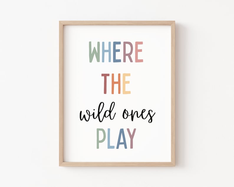 May include: A framed print with the text "WHERE THE wild ones PLAY" in a rainbow of colors. The text is in a modern font and is centered on the white background.