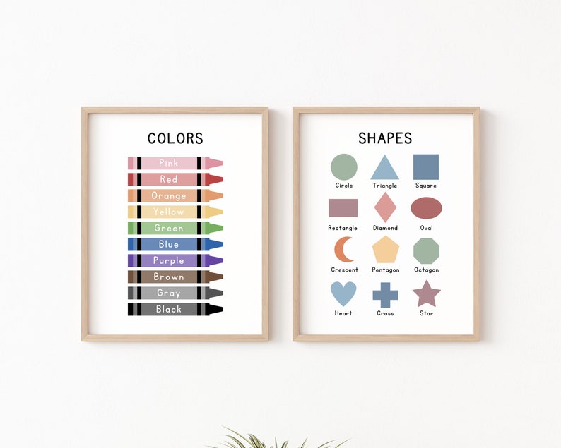 May include: Two framed educational posters for children. The left poster shows a set of crayons with the names of colors written below each crayon. The right poster shows a set of shapes with the names of each shape written below each shape.