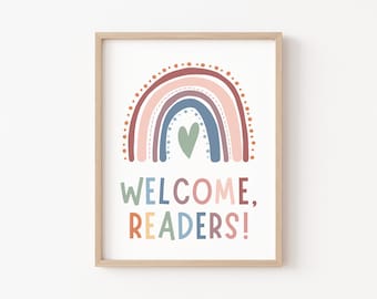 May include: A framed print featuring a rainbow in shades of pink, red, purple, blue, and green with a small green heart in the centre. The text "WELCOME, READERS!" is below the rainbow.
