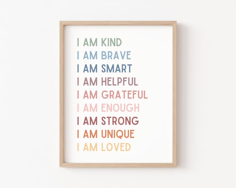 K&ouml;nnte beinhalten: Ein gerahmter Druck mit dem Text "Ich bin freundlich, ich bin mutig, ich bin klug, ich bin hilfsbereit, ich bin dankbar, ich bin genug, ich bin stark, ich bin einzigartig, ich bin geliebt" in einem Regenbogenfarbverlauf.