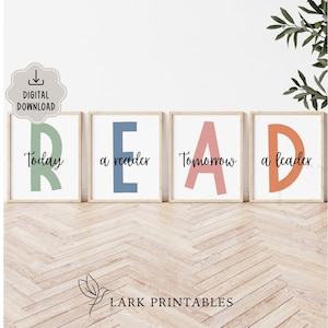 Può includere: Quattro stampe incorniciate con la parola «READ». Ogni cornice ha una lettera di colore diverso: verde, blu, rosa e arancione. Le parole «Today», «a reader», «Tomorrow» e «a leader» sono scritte sotto le lettere. Le stampe sono su un pavimento in legno chiaro.
