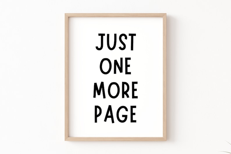 May include: A framed print with the text "JUST ONE MORE PAGE" in black lettering on a white background.