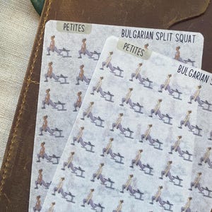 May include: Two sticker sheets with a repeating pattern of a person doing a Bulgarian split squat exercise. The stickers have the text "PETITES" and "BULGARIAN SPLIT SQUAT". The stickers are on a brown leather surface.