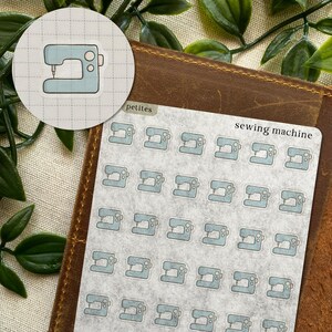 May include: A sheet of stickers featuring light blue sewing machine illustrations. The stickers are arranged on a gray background with the words "sewing machine" printed in black. A round sticker with a sewing machine is also visible.