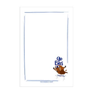 May include: A white notepad with a blue border and a cartoon buffalo wearing a blue and red helmet. The buffalo is jumping over a table with the text "Go Bills" above it. The notepad has the text "The Doodle Shop" at the bottom.