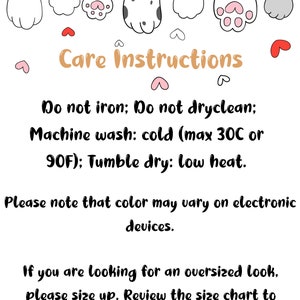 May include: White background with cartoon cat paws at the top. Text in the center reads "Care Instructions". The instructions include: do not iron, do not dry clean, machine wash cold (max 30C or 90F), and tumble dry low heat. Additional text advises that colors may vary on electronic devices and to size up for an oversized look.