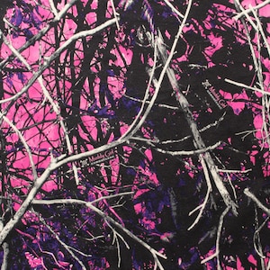 May include: Pink and black camouflage pattern with white branches. The pattern includes the text "Muddy Girl" in black.