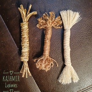 May include: Three different types of natural fiber rope, each with a unique texture and color. The rope on the left is a light brown, the rope in the middle is a darker brown, and the rope on the right is a light beige. The rope is arranged on a brown leather surface. The text "KASHMIR Luxuries" is visible in the lower left corner of the image.
