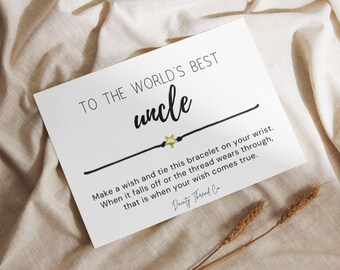 May include: A white ceramic mug with a black handle and the text "But First, Coffee" in a bold, black font. The mug is set against a blurred background, suggesting a cosy setting.