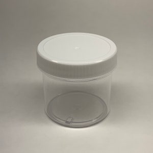 May include: A clear plastic jar with a white lid. The jar is empty and has a smooth, rounded bottom.