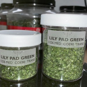 May include: Two glass jars filled with green glass frit, labeled "Lily Pad Green 1226 Med COE90 Trans".