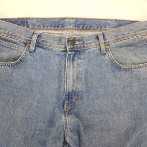 May include: A pair of blue denim jeans with a classic five-pocket style. The jeans have a light wash and a straight leg.