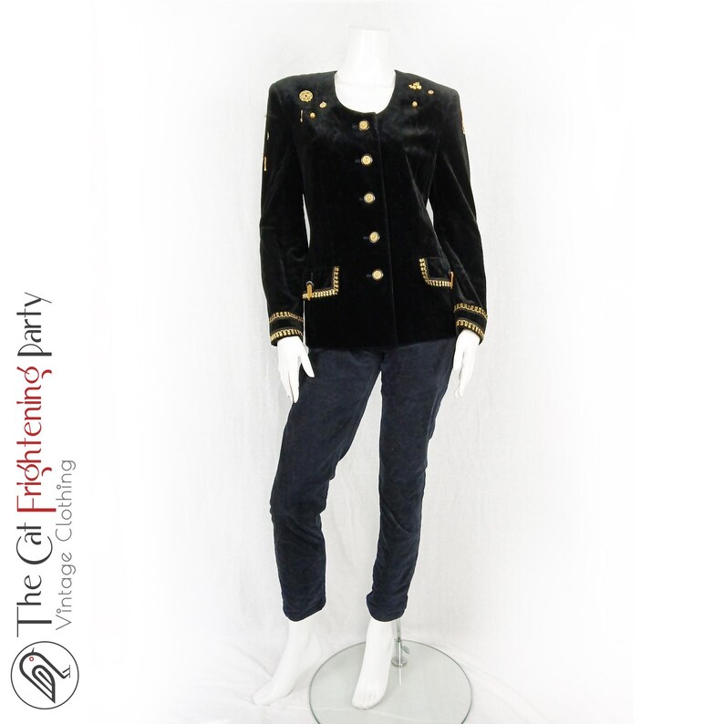 May include: A black velvet blazer with gold buttons and trim. The blazer has a round neckline and long sleeves. The blazer is decorated with gold embellishments.