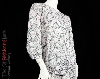 May include: A pink and gray floral print dress with a gathered skirt and three-quarter sleeves.