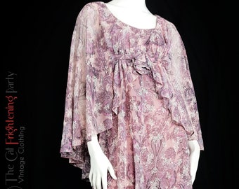 May include: A pink and purple floral print maxi dress with a ruffled neckline and long, flowing sleeves. The dress has a loose, flowing fit and is made of a lightweight fabric.
