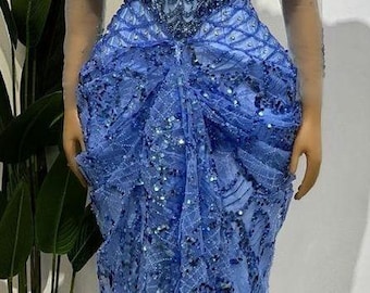 May include: A long, light blue gown with a beaded bodice and a flowing skirt. The gown has a sweetheart neckline and off-the-shoulder sleeves.