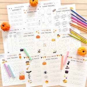 May include: Halloween-themed educational activity sheets for kids. Includes alphabet, number, shape, and word tracing, plus candy coloring pages. Features pumpkins, ghosts, and other festive illustrations. Colored pencils and markers are also visible.