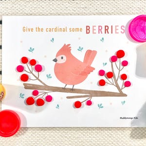 May include: A white card with a pink cardinal bird on a branch with red berries. The card says "Give the cardinal some BERRIES". There are containers of red and yellow playdough next to the card.