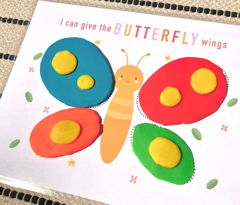 May include: A printable activity for kids to give a butterfly wings using play dough. The image shows a butterfly with a blue, red, and green wing outlines. The text "I can give the BUTTERFLY wings" is printed on the page.