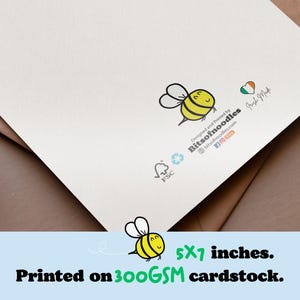 May include: A white card with a cartoon bee illustration and the text "Designed and Printed by Bitsofnoodles". The card measures 5x7 inches and is printed on 300 GSM cardstock.