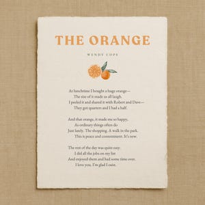 May include: A printed card with the title "THE ORANGE" in orange letters, with the author's name, Wendy Cope, below. The card features an illustration of an orange and text of a poem about an orange.