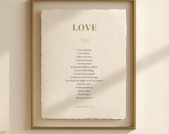 May include: A framed print with the word "LOVE" at the top, followed by a poem about love. The print is in a gold frame, and the text is in a simple, elegant font. The paper has a textured, off-white appearance.