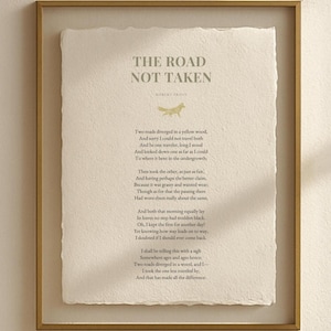 Könnte beinhalten: Gerahmter Druck des Gedichts "The Road Not Taken" von Robert Frost. Der Text ist in einer Serifenschrift auf strukturiertem, cremefarbenem Papier. Der Rahmen ist aus dünnem, goldfarbenem Metall. Eine kleine Fuchsgrafik ist oben.
