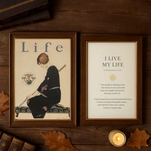以下が含まれることがあります： 茶色の木製フレームに入った2つのプリント。1つは上部に「Life」という言葉と黒いドレスを着た女性のイラストが特徴です。もう1つは「I LIVE MY LIFE」というテキストとライナー・マリア・リルケの詩が書かれています。