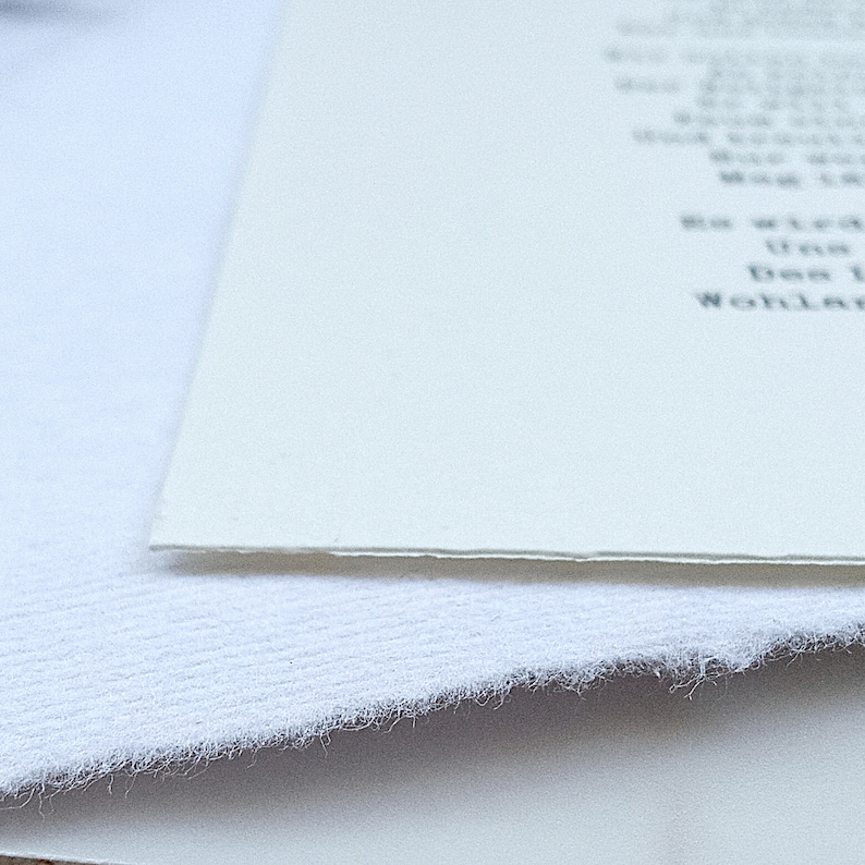 Może przedstawiać: Zbliżenie na białą kartkę papieru z nadrukowanym tekstem. Papier leży na białej, fakturowanej powierzchni.