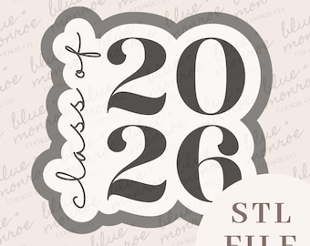 May include: A cookie cutter in the shape of a graduation cap with the text "Class of 2026" in a script font. The numbers "2026" are in a bold, sans-serif font. The words "STL FILE" are in a sans-serif font.