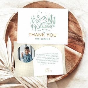 May include: Thank you card with a green and white illustration of a mountain range with a tent and stars. The card has a beige gingham background and a photo of a young boy in a blue shirt. The text on the card reads "Thank You for Coming" and "We are so grateful for your presence at Henry's birthday party. Thank you for taking the time to celebrate with us, and for your very generous gift. Henry is so blessed to have you in his life!" with love, The Millers.